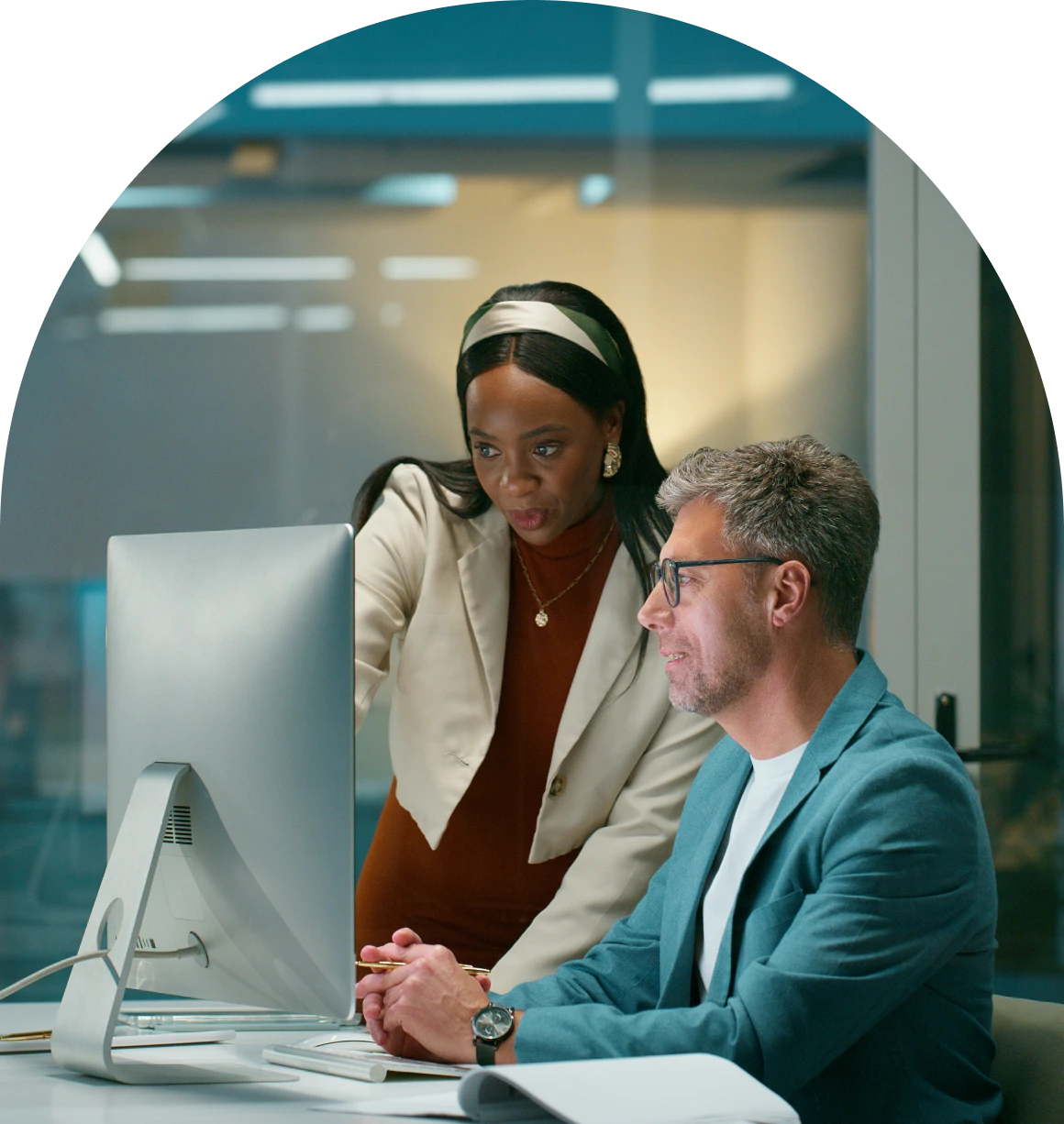 Man and woman sitting at a desk in front of a computer